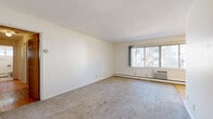Located at 4430 Chowen Ave S in Minneapolis, MN, this single-floor, 3-bedroom, 1-bathroom unit offers a functional and straightforward layout connected by a central hallway. The spacious primary bedroom is notably generous in size, featuring warm hardwood floors, a sliding mirrored closet door, and a window that brings in natural light with outdoor views of mature trees. The two additional bedrooms also showcase hardwood flooring and individual windows overlooking the surrounding neighborhood, providing a bright and airy feel. The main living area is finished with plush carpeting, white walls, and a ceiling fan, creating a comfortable and open atmosphere. A wall-mounted air conditioning unit and baseboard heating throughout ensure year-round climate control. The entryway, accented by a classic wood-toned door, transitions seamlessly into the living space. The bathroom features clean white subway tile surrounding a full bathtub, offering a simple and classic aesthetic. Natural light flows through windows in nearly every room, contributing to the overall brightness of the unit. The layout is efficient and well-organized, making practical use of the available space throughout.