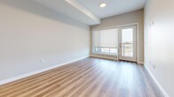 This well-appointed 2-bedroom, 2-bathroom unit at 28 Westhill Dr in Waterloo, Ontario offers a thoughtfully designed open-concept layout with modern finishes throughout. Light wood-tone laminate flooring flows seamlessly across the entire space, creating a bright and cohesive aesthetic.

The kitchen is a standout feature, showcasing a large central island with a crisp white quartz countertop and a dark wood-grain base, complemented by stainless steel appliances including a refrigerator, range, and built-in microwave. Upper cabinetry in clean white contrasts elegantly with the darker lower cabinets, while a subway tile backsplash and pendant lighting above the island add refined detail. The kitchen opens directly to the living area, which benefits from natural light and access to an outdoor balcony through glass doors.

Both bedrooms are comfortably sized, featuring large windows with roller blinds that allow ample natural light and views of the surrounding neighbourhood. The primary bedroom offers generous proportions ideal for a full bedroom suite.

The two bathrooms are finished with classic white subway tile. One features a soaking tub with full tile surround, while the other offers a glass-enclosed walk-in shower with built-in shelving. The overall design is clean, contemporary, and move-in ready.