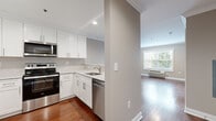 Located at 47 Legion Dr. in Bergenfield, NJ, this one-bedroom, one-bathroom residence offers a thoughtfully designed layout across a single floor. Rich hardwood flooring and crown molding flow consistently throughout the space, lending a cohesive and polished aesthetic.

The kitchen is a standout feature, equipped with a full suite of stainless steel appliances including a refrigerator, electric range, built-in microwave, and dishwasher. Crisp white shaker-style cabinetry pairs with light stone countertops and a classic tile backsplash, creating a clean, modern look. The kitchen opens toward the living area, enhancing the sense of flow between spaces.

The living room is bright and inviting, benefiting from a large window that allows natural light to fill the room, with views of greenery outside. Crown molding and a wall-mounted HVAC unit complete the space.

The bedroom is a comfortable size, also featuring hardwood floors, crown molding, a window with natural light, and direct access to a well-appointed walk-in closet outfitted with built-in shelving and hanging rods for organized storage.

The bathroom is cleanly finished with tile flooring, a white vanity with a mirrored medicine cabinet, and a full soaking tub with shower. Neutral tones throughout create a calm, functional environment.