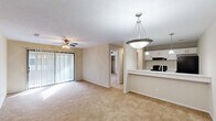 This single-floor, 3-bedroom, 1-bathroom home in Columbus, Georgia offers a practical and comfortable layout with a warm, neutral aesthetic throughout. The open-concept living area is bright and welcoming, featuring plush wall-to-wall carpeting, a ceiling fan with light, and large sliding glass doors dressed with vertical blinds that fill the space with natural light. The kitchen flows seamlessly from the living area via a peninsula counter finished with a light granite-style surface and served by pendant lighting overhead. White cabinetry, black appliances including a refrigerator and range, and an under-cabinet range hood give the kitchen a clean, functional appearance. An adjacent pantry provides additional storage. The primary bedroom is generously sized with carpet flooring, a ceiling fan, and direct access to a closet and the bathroom. The bathroom features a wide vanity with granite-style countertops, white cabinetry, wood-look flooring, and a separate water closet. Two additional bedrooms each include carpet flooring, ceiling fans, and windows that allow natural light. Each bedroom offers closet storage, with bifold doors providing easy access. A hallway connects the bedrooms and common areas, completing this well-organized, move-in-ready home.