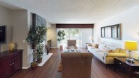 Located at 200 City Blvd W in Orange, California, this single-floor residence offers a well-appointed and cohesive living environment. The open living room is a standout space, featuring rich hardwood-style flooring, a dramatic floor-to-ceiling tiled fireplace, and a sliding glass door that floods the area with natural light and provides access to an outdoor patio with garden views. The layout flows naturally into a dedicated dining area, complete with a pendant chandelier, mirrored wall panel, and warm neutral tones that create an inviting atmosphere.

The kitchen is efficiently designed with dark wood cabinetry, light stone countertops, a decorative tile backsplash, and a full suite of stainless steel appliances including a range, over-the-range microwave, refrigerator, and dishwasher. A peninsula with bar seating connects the kitchen to the entryway, enhancing the open feel.

The bedroom is generously sized with plush carpeting, neutral wall tones, and a bank of large windows dressed with classic plantation shutters that offer both privacy and an outdoor view. The bathroom features clean white finishes, a stone-topped vanity, and wood-look flooring. Throughout the space, consistent design choices in flooring, cabinetry, and neutral palettes create a unified and comfortable feel.