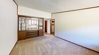 Located at 4110 Mountain Creek Rd in Chattanooga, TN, this single-floor, 2-bedroom, 1-bathroom home offers a functional and straightforward layout. The living area features neutral carpet flooring, white walls with warm wood trim, and a textured ceiling, creating a simple and practical atmosphere. A distinctive open wood shelving unit serves as a partial divider between the living room and kitchen, which is equipped with overhead cabinetry and appliances. A window in the front area allows natural light to filter in, with views of the surrounding greenery. The primary bedroom includes a ceiling fan with light fixture, a sliding wood-panel closet, and soft carpeting throughout. The second bedroom is similarly carpeted and features a large window that lets in ample natural light. The full bathroom is outfitted with tile flooring, a single-sink vanity with a marble-style countertop, a toilet, and a full tub-shower combo. A dedicated utility room provides additional functional space, housing the water heater. Consistent wood trim detailing and textured ceilings tie the home together with a cohesive, understated aesthetic throughout.