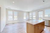 Located at 22624 E Radcliff Cir in Aurora, CO, this single-story, 3-bedroom, 2-bathroom home offers a clean, contemporary design with a well-planned open-concept layout. Light wood-tone flooring runs throughout, complementing the neutral palette of crisp white walls and modern finishes.

The kitchen is a standout feature, showcasing warm wood cabinetry extending to the ceiling, a classic tile backsplash, stainless steel appliances including a range, microwave, dishwasher, and refrigerator, and a central island with a bright white countertop. The adjoining living area is bright and airy, with multiple windows that invite generous natural light and provide views of the surrounding neighborhood.

A well-lit hallway connects the three bedrooms, each featuring the same light wood flooring and roller shade-equipped windows. The primary bedroom offers comfortable proportions with multiple windows and direct access to a private bathroom. The primary bath includes a walk-in shower, a wood-tone vanity with white countertop, and a connected walk-in closet with built-in rod and shelving. A second full bathroom serves the remaining bedrooms. Additional storage is provided by two closets throughout the home. The overall ambiance is bright, clean, and move-in ready.