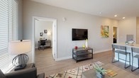 Located in Denver's vibrant West Colfax neighborhood, this single-floor residence offers a thoughtfully designed layout with modern finishes throughout. The open-concept kitchen is a standout feature, showcasing stainless steel appliances including a refrigerator, range, microwave, and dishwasher, complemented by two-tone cabinetry — white upper cabinets paired with warm wood-toned lower cabinets — and a classic white subway tile backsplash. Light wood-look flooring flows seamlessly through the main living areas, adding warmth and cohesion to the space. The living room is bright and inviting, benefiting from large windows and a sliding glass door that floods the space with natural light and provides views of the surrounding neighborhood. Multiple bedrooms offer comfortable and versatile accommodations, each with wood-look flooring, ample natural light, and neutral wall tones that create a calm, restful atmosphere. The bathrooms are well-appointed with modern vanities featuring wood-toned cabinetry, large mirrors, light countertops, and glass-enclosed showers. Clean lines, recessed lighting, and a consistent neutral palette throughout the residence contribute to a cohesive, contemporary aesthetic well-suited to modern urban living.