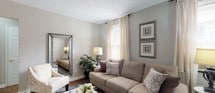 Located at 1701 Walker Ave in Union, New Jersey, this single-floor home offers a thoughtfully designed layout with a warm, neutral color palette and hardwood flooring that flows throughout the main living areas. The inviting living room features a textured ceiling, large windows dressed with sheer cream curtains that allow abundant natural light, and ample space for comfortable seating and décor. A defined dining area with a round table and bold accent chairs sits adjacent to the living room, creating a cohesive open feel. The primary bedroom is a serene retreat, complete with a ceiling fan, hardwood floors, soft carpeting, and windows framed by delicate sheer drapes. A second bedroom provides versatility with hardwood floors, natural light from a window with a Roman shade, a ceiling light fixture, and chair rail detailing along the walls. The bathroom is finished with clean white tile flooring, a tiled tub and shower surround accented by a decorative mosaic border, and a bright, minimalist aesthetic. Throughout the home, soft gray walls, classic white trim, and carefully chosen finishes contribute to a cohesive and welcoming atmosphere suited for comfortable everyday living.