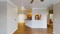 Located on Decree Place in Cary, NC, this single-floor residence offers a well-designed layout with a seamless flow between living and functional spaces. The open-concept living and dining area features warm hardwood-style flooring, crown molding, and a ceiling fan, creating a comfortable and inviting atmosphere. A pass-through window connects the living area to the kitchen, which is outfitted with honey-toned cabinetry, granite-style countertops, a tile backsplash, and stainless steel appliances including a refrigerator, range, microwave, and dishwasher. A peninsula with additional counter space adds to the kitchen's functionality.

The bedrooms are carpeted for comfort and each includes a ceiling fan and natural light from large windows with blinds. The primary bathroom features a dual-sink vanity with warm wood cabinetry and a full-width mirror, while the secondary bathroom offers a tiled shower-tub combo with chrome fixtures. Both bathrooms include hardwood-style flooring. A dedicated laundry area houses a full-size side-by-side washer and dryer with overhead wire shelving for added storage. Neutral tones throughout the space create a clean, cohesive aesthetic well-suited for everyday living.