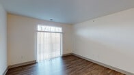 Located at 8383 Brandt Pike in Huber Heights, Ohio, this single-floor unit offers a clean, modern aesthetic throughout. The open-concept living area features rich hardwood-style flooring and neutral walls, creating a bright and welcoming atmosphere. A sliding glass door with vertical blinds allows natural light to fill the space while providing access to the outdoors.

The kitchen is thoughtfully designed with white shaker-style cabinetry, granite countertops, and a full suite of stainless steel appliances, including a refrigerator, electric range, built-in microwave, and dishwasher. A pendant light fixture adds a contemporary touch above the sink area.

The unit includes two bedrooms, both carpeted for comfort. One bedroom features dual windows that bring in ample natural light, while the other includes a private en-suite bathroom. The en-suite bath is equipped with a walk-in glass-door shower, a granite-topped vanity, and industrial-style light fixtures. A second full bathroom features a shower-tub combination, granite vanity, and matching finishes, ensuring a cohesive design throughout.

Consistent hardwood-style flooring runs through the main living areas, tying the spaces together with a warm, unified look. The overall design balances functionality and modern style in a comfortable, single-level layout.
