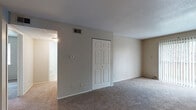 Located at 1645 SW 37th Terrace in Topeka, Kansas, this single-floor unit offers a practical and well-organized layout designed for comfortable everyday living. The living area is generously sized, featuring neutral-toned carpet, a ceiling fan with light fixture, and a sliding glass door that allows natural light to flow in while providing outdoor access. The space connects openly to the kitchen, which is a notable highlight of the unit. The kitchen is outfitted with dark cabinetry, granite-style countertops, stainless steel appliances including a refrigerator and range, and tile flooring, creating a functional and stylish cooking environment.

The bedrooms are carpeted and well-proportioned, each featuring windows with blinds that bring in natural light. Closet storage is well-represented throughout, with both standard and double-door closet configurations providing ample room for personal storage. One bedroom features vertical wood panel wall detail, adding a subtle design element.

The bathrooms are finished with tile flooring, dark vanity cabinetry, and light-toned countertops. One bathroom includes additional open shelving, enhancing storage utility. Textured ceilings are consistent throughout the unit, contributing to its classic residential character. Overall, the space presents a clean, neutral palette well-suited for a variety of furnishing styles.