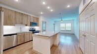 This single-story residence offers a thoughtfully designed layout across two bedrooms and two full bathrooms. The open-concept kitchen and living area forms the heart of the home, where light wood-tone cabinetry, granite countertops, and a kitchen island with a built-in wine cooler create a functional and stylish hub. Stainless steel appliances, a subway tile backsplash, and recessed lighting complete the kitchen. The living room extends seamlessly from the kitchen, featuring light hardwood-style flooring, a ceiling fan, and large windows with blinds that invite natural light throughout the day.

The primary bedroom is a comfortable retreat, carpeted for warmth, with multiple windows and a barn-style closet door leading to a dedicated closet. It connects directly to a private en-suite bathroom featuring a granite-topped vanity, wood cabinetry, hardwood-style flooring, and a bathtub-shower combination. The second bedroom mirrors a similar layout with carpet flooring, natural light from dual windows, and a ceiling fan. The second full bathroom is equally well-finished with matching granite countertops and a tub-shower combo. Throughout the residence, a consistent palette of whites and warm wood tones creates a clean, modern ambiance.