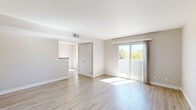This single-floor, 2-bedroom, 2-bathroom residence offers a bright and functional layout thoughtfully designed to maximize comfort. The living room is a welcoming, open space featuring light hardwood-style flooring, neutral-toned walls, and a textured ceiling. Sliding glass doors flood the room with natural light and provide direct access to a private patio with outdoor views of surrounding greenery.

The kitchen is efficiently laid out with white cabinetry, stone-look countertops, and a full suite of stainless steel appliances including a range, microwave, and refrigerator. A peninsula counter separates the kitchen from the dining area, which benefits from a large window framing pleasant outdoor views.

Both bedrooms are carpeted for warmth and comfort, each offering generous proportions, neutral walls, and ample closet space with sliding-door closets. The primary bedroom provides a notably comfortable footprint. Four closets throughout the unit ensure substantial storage throughout.

The two bathrooms are clean and functional — one features a soaking tub/shower combination, while the other offers a dedicated stand-up shower. Both are finished with light hardwood-style flooring and neutral tones. A utility room and dedicated entrance complete this practical and well-organized residence.