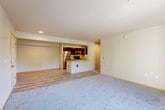 Located at 13004 Meridian Ave S in Everett, WA, this 4-bedroom, 2-bathroom unit offers a thoughtfully laid-out single-floor floor plan designed for comfortable everyday living. The open-concept living and dining area features plush carpeting and neutral-toned walls, creating a bright and welcoming atmosphere. The kitchen flows seamlessly into the living space via a peninsula-style counter with a built-in sink, complemented by dark wood cabinetry, stainless steel appliances including a refrigerator, microwave, and range, and light hardwood-style flooring that extends throughout the kitchen and entryway. Recessed lighting illuminates the space efficiently. A hallway leads to the four bedrooms, each featuring soft carpeting and ample natural light from well-placed windows with views of the surrounding neighborhood. The primary bedroom is generously sized and includes a walk-in closet with wrap-around wire shelving, offering excellent storage capacity. Additional bedrooms are served by a closet with built-in shelving. The two bathrooms are finished with tile flooring and include a full tub-shower combination. A dedicated closet provides extra storage to round out this well-appointed home.