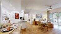 This thoughtfully designed single-floor residence offers 1 bedroom and 2 full bathrooms within a comfortable and efficiently arranged floor plan. The open-concept living, dining, and kitchen area forms the heart of the home, unified by warm-toned hardwood-style flooring and bright white walls that create a clean, welcoming ambiance. The living room features a ceiling fan, a sliding glass door that invites natural light and provides access to an outdoor area, and ample space for relaxed entertaining. Adjacent to the living room, the dining area is illuminated by a statement pendant light and flows seamlessly toward the in-unit laundry room, which houses a full-size washer and dryer alongside a water heater. The galley kitchen is well-equipped with white shaker cabinetry, white appliances, and generous counter space on both sides, offering a practical and attractive cooking environment. The generously sized primary bedroom features plush carpet flooring, a ceiling fan, a large window with natural light, and direct access to a dedicated closet and study nook. Both bathrooms are finished with white shaker vanities, white quartz countertops, hardwood-style flooring, and tub-shower combinations, maintaining a consistent, polished aesthetic throughout.