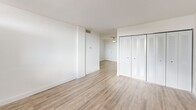 Located at 999 NE 167th St in North Miami Beach, FL, this one-bedroom, one-bathroom residence offers a clean, bright, and efficiently designed living space. Throughout the unit, light-toned wood-look flooring provides a cohesive aesthetic, complemented by crisp white walls and white baseboards that enhance the sense of openness.

The open-concept living, dining, and kitchen area forms the heart of the unit. The living and dining space receives natural light through sliding windows that frame views of surrounding palm trees, reinforcing the South Florida atmosphere. The kitchen features white cabinetry and white appliances, maintaining the unit's consistent, light-filled palette.

The bedroom is a well-proportioned retreat equipped with a ceiling fan and a window that allows in natural light and tropical views. The room also includes closet storage with louvered bifold doors. Across the unit, four closets in total provide generous storage capacity.

The bathroom features tile flooring, a tub-shower combination with mosaic tile accent detailing, and recessed lighting. A dedicated laundry area houses a stacked Samsung washer and dryer, adding in-unit convenience. The unit also includes a private balcony, a water heater, and an individual electrical panel. This residence offers a functional and well-appointed layout in a convenient North Miami Beach location.