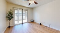 Located at 960 N Gilbert Rd in Gilbert, Arizona, this single-story, one-bedroom, one-bathroom unit offers a thoughtfully designed layout that maximizes its compact footprint. Light wood-style flooring runs throughout the space, lending a clean, cohesive feel to every room. Textured ceilings and ceiling fans are found in multiple rooms, contributing to both comfort and a consistent aesthetic.

The open-concept kitchen is outfitted with white cabinetry, a white countertop peninsula, a black appliance suite including a refrigerator, range, microwave, and dishwasher, and a stacked in-unit washer and dryer—an especially practical feature. The kitchen connects seamlessly to the living area, creating a functional and social layout.

The living room is bright and airy, featuring a sliding glass door with vertical blinds that opens to a private outdoor patio, allowing natural light to fill the space. The bedroom is a comfortable size, equipped with its own ceiling fan and a window that brings in additional natural light. A dedicated closet provides ample storage.

The bathroom includes a full tub-shower combination with clean white surround, a toilet, and a countertop vanity. Neutral wall tones throughout the unit create a calm, move-in-ready atmosphere well-suited for everyday living in the Gilbert, AZ area.