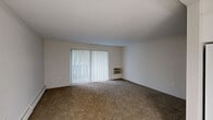 This 2-bedroom, 1-bathroom single-floor residence at 44 Brittany Farms Rd in New Britain, CT offers a practical and comfortable layout across a well-proportioned floor plan. The living room is a generous, carpet-floored space featuring a wall-mounted air conditioning unit and a sliding glass door fitted with vertical blinds that opens to a private balcony, allowing natural light and outdoor views to enhance the room's ambiance. Baseboard heating runs throughout the unit for consistent warmth.

The kitchen is neatly appointed with white shaker-style cabinetry, dark granite-look countertops, a full suite of appliances including a gas range, dishwasher, and refrigerator, and a stainless steel microwave. Light tile flooring and a decorative chandelier give the kitchen a clean, inviting feel.

The spacious primary bedroom features carpet flooring, a large window with outdoor views, and access to a dedicated closet equipped with a full-width wire shelving and hanging system. The second bedroom is similarly carpeted and includes its own closet with bifold doors. The full bathroom offers a clean, white tub-shower combination with chrome fixtures. Additional storage is provided by a separate walk-in closet accessible from the main living area.