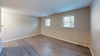 Located at 430 Yorkshire St in Salem, VA, this single-floor unit offers a clean, updated interior with a neutral color palette throughout. The kitchen is a standout feature, equipped with white shaker-style cabinetry, light granite countertops, a stainless steel double-basin sink, and a white subway tile backsplash. Stainless steel appliances—including a refrigerator, dishwasher, and electric range—complement the space, which is finished with durable wood-look plank flooring.

The living areas feature the same wood-look flooring, providing a cohesive and easy-to-maintain surface. Multiple windows allow natural light to fill these spaces, offering views of the surrounding greenery. The bedrooms are carpeted for added comfort and include sliding-door closets with built-in hanging rods, providing practical storage. A window in each bedroom brings in additional natural light.

The bathroom includes a tub-shower combination with a white surround, wood-look tile flooring, a single vanity, and a window with blinds for privacy and ventilation. The 3D floor plan reveals a well-organized, compact layout that efficiently connects the kitchen, living areas, bedrooms, and bathroom. Clean white trim and baseboards throughout add a polished, finished look to the space.