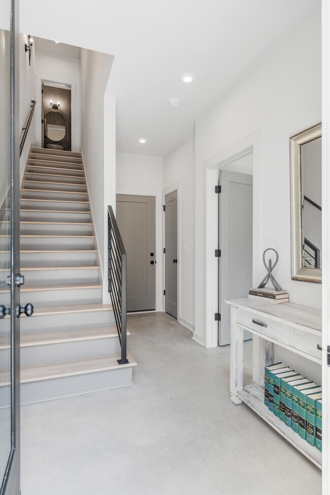 Entrada que se siente abierta y elevada, con acceso a una suite privada y baño en el primer piso. - 358 E Village Ln