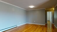 Located at 45 Farm Rd in Hillsborough, NJ, this single-floor unit offers a well-maintained and functional layout. Warm-toned hardwood flooring extends throughout the living areas and bedrooms, lending a cohesive and polished appearance to the space. Several of the rooms feature elegant crown molding and flush-mount ceiling light fixtures, adding a refined architectural detail to the otherwise clean, neutral interiors. Baseboard heating units are present throughout, ensuring consistent climate control across all rooms.

The kitchen stands out with white shaker-style cabinetry, granite-look countertops, and a full suite of stainless steel appliances, including a range, over-the-range microwave, and dishwasher. A window above the sink provides natural light, while light wood-tone flooring completes the bright, functional space.

The bedrooms are generously proportioned, with clean white walls and hardwood floors. One bedroom features dual windows that bring in natural light and offer views of the surrounding greenery. The bathroom is neatly appointed with tile flooring, a tub and shower combination enclosed by sliding glass doors, and a vanity with ample storage. Overall, the unit presents a tidy, move-in-ready environment.