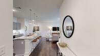Located along Historic Highway in Demorest, Georgia, this thoughtfully designed single-floor residence offers 2 bedrooms and 3 bathrooms within a comfortable and efficiently arranged floor plan. The open-concept kitchen and living area serves as the heart of the home, featuring granite countertops, gray shaker cabinetry, stainless steel appliances, a white subway tile backsplash, and a large island with seating — ideal for both cooking and entertaining. Pendant lighting and dark hardwood-style flooring add a modern, polished touch throughout. A stackable in-unit washer and dryer is conveniently tucked nearby. The bright living room benefits from large windows that invite ample natural light and views of the surrounding greenery, creating a warm and welcoming atmosphere. The primary bedroom is generously sized and features plush carpeting, a ceiling fan, and access to a dedicated walk-in closet with dual hanging rods. The second bedroom also offers built-in closet storage and carpeted flooring. The bathrooms are well-finished, with one featuring a tub-shower combination with granite vanity, and another offering a spacious walk-in shower with built-in shelving. Clean white walls and neutral tones throughout lend the space a bright, contemporary feel.