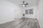 Located at 854 S Oxford Ave, this one-bedroom, one-bathroom unit offers an efficiently designed single-floor layout. The living area is bright and open, featuring light gray luxury vinyl plank flooring that runs throughout and crisp white walls that reflect natural light. A ceiling fan with a built-in light fixture is centrally mounted, providing both airflow and ambient lighting. Windows along the exterior wall allow natural light to filter in, enhancing the airy feel of the space.

The spacious primary bedroom accounts for the majority of the floor area, offering generous room for furnishings and comfortable everyday living. Two closets provide ample storage throughout the unit.

The kitchen is finished with a clean, modern aesthetic, showcasing white shaker-style cabinetry, brushed gold hardware, and a double-basin sink. Marble-look tile flooring grounds the space, while a gas range adds full cooking functionality. The layout is galley-style, making efficient use of the available space.

The bathroom is finished in an all-white palette, featuring LVP flooring consistent with the rest of the unit, a full shower-tub combination, a toilet, and a vanity with storage. The overall design of the unit is clean, cohesive, and move-in ready.