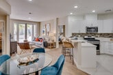 Located at 1311 Sepulveda Blvd in Torrance, California, this well-appointed single-floor residence offers a thoughtfully designed open-concept layout that seamlessly connects the living, dining, and kitchen areas. Light wood-style flooring runs throughout the main living spaces, complementing the bright, neutral color palette and recessed lighting overhead.

The kitchen is a standout feature, outfitted with crisp white shaker cabinetry, quartz countertops, a mosaic tile backsplash, and a full suite of stainless steel appliances including a gas range, over-the-range microwave, and refrigerator. A breakfast bar with seating provides a casual dining option that opens directly to the living area.

The living room is filled with natural light, highlighted by sliding glass doors that lead to an outdoor patio area with views of lush greenery and palm trees, lending a relaxed Southern California ambiance. The bedrooms are well-proportioned and naturally lit; one features a serene coastal-inspired design with blue accent walls, while another offers a calm, neutral retreat. Both bathrooms are finished with white vanities, large mirrors, and combination tub/shower units. The overall design is clean, modern, and cohesive throughout.