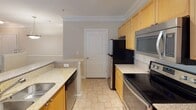 This single-floor residence at 1340–1364 Clairmont Road in Decatur, Georgia, offers a well-organized layout with distinct living, kitchen, and bathroom areas. Crown molding throughout adds a refined architectural touch, lending a polished feel to each room.

The kitchen is a standout feature, equipped with stainless steel appliances including a refrigerator, electric range, and over-the-range microwave. Light wood cabinetry pairs with granite-look countertops, and tile flooring runs underfoot. A peninsula with a sink provides additional prep space and opens the kitchen toward the adjacent living area, which benefits from track lighting and a window allowing natural light to enter.

The living area, as revealed in the floor plan scan, features wood-look flooring and flows through an open, connected layout. The bedroom is carpeted and includes a large window fitted with horizontal blinds, offering views of surrounding greenery and providing ample natural light.

The bathroom features a soaking tub with a tiled surround, brushed nickel fixtures, and a clean, neutral palette. Tile flooring completes the space with a practical and cohesive finish. Overall, the unit presents a functional and comfortable living environment in the Decatur area.