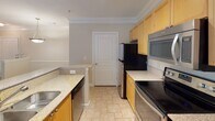 This single-floor residence at 1340–1364 Clairmont Road in Decatur, Georgia, offers a well-organized layout with distinct living, kitchen, and bathroom areas. Crown molding throughout adds a refined architectural touch, lending a polished feel to each room.

The kitchen is a standout feature, equipped with stainless steel appliances including a refrigerator, electric range, and over-the-range microwave. Light wood cabinetry pairs with granite-look countertops, and tile flooring runs underfoot. A peninsula with a sink provides additional prep space and opens the kitchen toward the adjacent living area, which benefits from track lighting and a window allowing natural light to enter.

The living area, as revealed in the floor plan scan, features wood-look flooring and flows through an open, connected layout. The bedroom is carpeted and includes a large window fitted with horizontal blinds, offering views of surrounding greenery and providing ample natural light.

The bathroom features a soaking tub with a tiled surround, brushed nickel fixtures, and a clean, neutral palette. Tile flooring completes the space with a practical and cohesive finish. Overall, the unit presents a functional and comfortable living environment in the Decatur area.