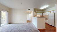 Located at 8000 Painted Desert Dr in Roseville, CA, this 2-bedroom, 2-bathroom residence offers a well-organized single-level floor plan with a thoughtful blend of comfort and functionality. The open-concept living area flows seamlessly into the kitchen, which features a U-shaped layout with white cabinetry accented by warm wood trim, a full suite of appliances including an electric range, dishwasher, and refrigerator, and rich hardwood-style flooring that extends throughout the kitchen and hallway areas. A peninsula counter separates the kitchen from the carpeted living room, creating a natural transition between spaces. The primary bedroom is a comfortable retreat with plush carpeting, access to a private balcony overlooking mature trees, and an en-suite bathroom equipped with a walk-in shower featuring gold-tone sliding glass doors and a single-sink vanity. The second bedroom offers soft carpeting, two generously sized windows with outdoor views, and a closet with built-in shelving. The second bathroom includes a full soaking tub and shower combination. A hallway connects all rooms, providing a clean and efficient layout. The unit is finished in neutral tones throughout, creating a bright and airy atmosphere.