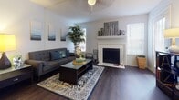 This single-story residence offers a thoughtfully designed layout that balances comfort and functionality across its key living spaces. The living room serves as the heart of the home, highlighted by a classic white-mantled fireplace, rich dark hardwood-style flooring, and a ceiling fan overhead. Natural light filters in through multiple windows fitted with blinds, creating a bright and welcoming atmosphere. A decorative entryway console and patterned area rug add character to the open layout, which also provides direct access to an exterior door.

The kitchen is efficiently arranged with grey cabinetry, a subway tile backsplash, stainless steel appliances including a full-size refrigerator and electric range with overhead ventilation, and light countertops. A double sink and a pass-through counter enhance the kitchen's practicality.

The bedroom is a serene retreat featuring dark hardwood-style flooring, a ceiling fan, sheer-curtained windows that invite natural light, and neutral wall tones that contribute to a calm ambiance. Ample dresser space and thoughtful décor complete the room.

The bathroom is clean and functional, offering a tub-shower combination, a vanity with a marble-look countertop, grey cabinetry, and a large mirror with overhead lighting. Textured wall tiles and dark flooring tie the space together cohesively.