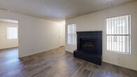 Located at 4225 E University Dr in Mesa, AZ, this single-story 2-bedroom, 2-bathroom residence offers a functional and comfortable layout across a well-utilized floor plan. The living room serves as the heart of the home, anchored by a striking dark brick fireplace and complemented by wood-look flooring that runs throughout the unit. Natural light filters in through vertical-blind-covered windows, creating a bright and welcoming ambiance with a textured ceiling overhead. The galley-style kitchen is efficiently designed with warm oak cabinetry lining both walls, ample counter space, a double sink, and white appliances including a refrigerator, electric range, and dishwasher. A utility room provides additional practical storage and access. Both bedrooms are comfortably sized, each featuring wood-look flooring, ceiling fans with light fixtures, and windows with vertical blinds. The primary bedroom includes its own dedicated closet. Each of the two bathrooms is clean and straightforward, featuring a full tub-shower combo with a white surround, wood-look flooring, and neutral walls. A second closet provides additional storage within the unit, rounding out this well-organized and move-in-ready Mesa residence.