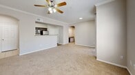 Located at 8585 Woodway Dr in Houston, Texas, this single-floor residence offers a thoughtfully designed layout that maximizes comfort and functionality. The open-concept living room is finished with plush wall-to-wall carpeting, crown molding, and a ceiling fan with a light fixture, creating a bright and inviting atmosphere. Large windows fitted with blinds allow generous natural light to fill the space, while a sliding glass door provides access to the outdoors. The kitchen is positioned adjacent to the living area and features a peninsula with granite countertops, dark espresso cabinetry with glass-front upper cabinets, stainless steel appliances, and wood-look flooring, making it both stylish and practical. An arched passageway leads from the living area into the hallway, connecting the remaining rooms seamlessly. The bathroom is well-equipped with a granite-topped vanity, dark cabinetry, a combined shower and bathtub, and wood-look flooring, with direct access to a walk-in closet. A dedicated laundry area adds everyday convenience. Neutral tones throughout, combined with crown molding and clean finishes, give this residence a cohesive and polished look.