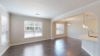 This single-floor, one-bedroom, one-bathroom home in Houston, TX (77090) offers a well-designed layout with consistent, quality finishes throughout. Dark hardwood-style flooring flows through the main living areas, complementing neutral warm-beige walls and crisp white crown molding that accents every room.

The open living and dining area is generously proportioned, filled with natural light from multiple windows fitted with horizontal blinds. A graceful arched passageway connects the living space to the dining area, which features a pendant light fixture overhead, adding a refined touch.

The kitchen is equipped with dark espresso cabinetry, a light-toned countertop, and a full suite of stainless steel appliances including a refrigerator, range, microwave, and dishwasher. A peninsula with an undermount sink and pendant lighting above provides additional workspace and a casual dining option.

The bedroom is a comfortable retreat with a ceiling fan, crown molding, a window with natural views, and access to a walk-in closet. The bathroom features a combined tub and shower with tiled surround, dark cabinetry with a light countertop vanity, and hardwood-style flooring.

An attached garage with an automatic opener provides secure, convenient parking and additional storage space.