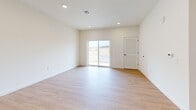 Located at 15 Ore Bank Rd in Dillsburg, PA, this thoughtfully designed one-bedroom, one-bathroom unit offers a clean, modern aesthetic across a single well-organized floor. The open-concept kitchen and living area forms the heart of the space, anchored by a large center island with a white quartz countertop, undermount sink, and built-in dishwasher. Gray shaker-style cabinetry lines the kitchen walls, complemented by a full suite of stainless steel appliances including a refrigerator, range, and microwave. Pendant lighting above the island adds a contemporary touch, while recessed lighting illuminates the entire open area. Light-toned hardwood flooring flows throughout the main living spaces, creating a warm and cohesive feel. The living area is spacious and bright, with sliding glass doors that open to an outdoor view, inviting natural light deep into the room. The bedroom features plush carpeting and a window with exterior views, offering a comfortable and quiet retreat. An additional bonus room with carpet provides flexible space for a home office or storage. The full bathroom is finished with gray cabinetry, a white vanity top, and a tub-shower combination. A utility room completes the layout, adding practical functionality to this well-appointed unit.