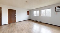 Located at 340 29th Street Dr SE in Cedar Rapids, Iowa, this 2-bedroom, 1-bathroom single-floor unit offers a practical and functional layout. The living room is a standout space, featuring light wood-look flooring, a charming stone-surround fireplace, and dual windows that invite natural light and outdoor views. Baseboard heating runs throughout the unit, and a wall-mounted A/C unit in the living area provides additional climate control.

The kitchen flows openly from the living area and is equipped with dark wood cabinetry, white appliances including a refrigerator, dishwasher, electric range with overhead ventilation, and a sink with ample counter space. A ceiling fan and easy access to the entry door make the kitchen-dining area both convenient and well-ventilated.

Both bedrooms feature plush carpeting, ceiling fans, and windows with neighborhood views. The primary bedroom includes a built-in closet with sliding wood-panel doors, while additional closets throughout the unit provide generous storage. The shared bathroom is clean and straightforward, offering a tiled tub-shower combo, a toilet, and a vanity with a white countertop set over wood-look tile flooring. With four closets total and a well-connected hallway, this unit provides organized, efficient living.