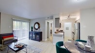This single-floor residence offers a cohesive, modern design highlighted by light wood-style flooring and a neutral gray-and-white color palette throughout. The open-concept living and dining area is generously proportioned, with a sliding glass door fitted with vertical blinds that fills the space with natural light and provides outdoor access. Built-in shelving adds functional character to the living area, which flows naturally into a dedicated dining space.

The galley-style kitchen features gray cabinetry, white quartz countertops, subway tile backsplash, and stainless steel appliances, including a full-size refrigerator and microwave. A peninsula counter connects the kitchen to the main living area.

The bedroom is a comfortable retreat, equipped with a ceiling fan, a window with blinds for natural light, and ample floor space. A walk-in closet area includes built-in shelving and houses the electrical panel.

Two bathrooms serve the residence. The primary bathroom offers a wide vanity with gray cabinetry, white countertop, a well-lit mirror, and a tub-shower combination with tiled surround. The secondary bathroom features similar tile work and a tub-shower setup. Light wood-style flooring carries throughout all areas of the home.