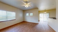Located at 1000 Diamond Dr in Boerne, Texas, this two-story residence offers a well-designed layout with practical finishes throughout. The main living area is open and airy, featuring warm wood-look flooring, a ceiling fan with light kit, and multiple windows dressed with blinds that invite natural light. A sliding glass door connects the living space to the outdoors, enhancing the sense of openness. The adjoining dining area flows naturally from the living room, illuminated by a hanging pendant light fixture.

The kitchen is efficiently arranged with light wood cabinetry, dark granite-style countertops, white appliances including a refrigerator, electric range, built-in microwave, and dishwasher. A breakfast bar provides additional counter space and a casual dining option. A dedicated interior door leads to a pantry or utility closet area.

A bathroom features a tiled shower-tub combination, wood cabinetry overhead, dark countertops at the vanity, and large mirrors. A convenient stacked washer and dryer unit is accessible nearby, adding in-unit laundry functionality.

The bedroom is carpeted for comfort, equipped with a ceiling fan, a natural window view, and a spacious reach-in closet. A staircase connects the two floors, offering additional living or storage space above.