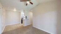 Located at 9850 S Kirkwood Rd in Houston, TX, this well-designed one-bedroom, one-bathroom residence offers a functional and comfortable layout across a single floor. The galley-style kitchen is thoughtfully appointed with gray cabinetry, granite-look countertops, a stainless steel refrigerator, and a dishwasher, all complemented by light wood-look flooring that extends throughout the main living areas. The combined kitchen and living room area benefits from vaulted ceilings that lend an open, airy feel, while a ceiling fan adds year-round comfort. A sliding glass door in the living area frames views of mature trees outside and opens the space to natural light, with built-in shelving alongside providing practical display and storage options. The carpeted bedroom is a comfortable size, featuring a ceiling fan and a window with natural light. A dedicated closet offers organized storage. The bathroom includes a full tub and shower combination with clean white tile surround. Neutral wall tones and consistent finishes throughout create a cohesive, move-in-ready environment. This residence is well-suited for those seeking a practical and comfortable home in the Houston area.