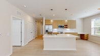 Located on Old Peachtree Road Northeast in Lawrenceville, Georgia, this thoughtfully designed single-floor residence offers three bedrooms, two bathrooms, and two closets within a bright, open layout. Light wood-tone flooring flows consistently throughout, lending warmth and continuity to every room.

The kitchen is a standout feature, showcasing flat-front natural wood cabinetry, white quartz countertops, a large center island with a deep basin sink, and a full suite of stainless steel appliances — including a side-by-side refrigerator with ice maker, electric range, and built-in microwave. Pendant glass lighting adds a refined touch above the island, while windows allow natural light to fill the adjoining living area.

The bedrooms are bright and airy, each equipped with ceiling fans and windows overlooking the outdoors. The spacious primary bedroom is accompanied by well-organized closet space featuring built-in shelving and hanging rods. A second closet offers additional storage.

The primary bathroom features a dual-sink vanity with natural wood cabinetry, white quartz countertops, pendant lighting, framed mirrors, and a marble-tiled walk-in shower. Clean, neutral wall tones throughout the home create a calm, modern ambiance ideal for comfortable everyday living.