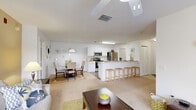 Located at 2302 Academy Cir W in Kissimmee, Florida, this well-appointed 2-bedroom, 2-bathroom single-floor residence offers a comfortable and functional layout designed for everyday living. The kitchen is a standout feature, outfitted with white cabinetry, stainless steel appliances including a refrigerator, range, microwave, and dishwasher, and wood-look flooring. A breakfast bar with seating connects the kitchen seamlessly to the living area, making it ideal for casual dining and entertaining. The living room is generously sized, featuring carpet flooring, a ceiling fan, and large windows dressed with grommet-panel curtains that allow ample natural light to fill the space. The primary bedroom is a comfortable retreat with soft carpet, a ceiling fan, soft blue accent wall, and sliding glass doors leading to a private balcony with outdoor views of the surrounding greenery. Both bedrooms are served by well-sized closets, including a spacious walk-in closet equipped with wire shelving and hanging rods for organized storage. The bathrooms feature tile flooring, a tub-shower combination, and neutral finishes throughout. A dedicated vanity area with a mirror adds a practical touch near the primary suite. The overall ambiance is light, airy, and move-in ready.