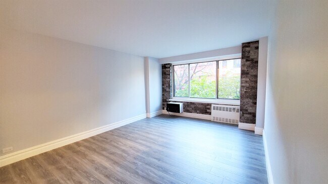 Living room detail include wood flooring and brick accent wall - 400 Central Park W
