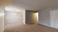 Located at 3111 S Leonard Springs Rd in Bloomington, Indiana, this one-bedroom, one-bathroom unit offers a practical and well-organized single-floor layout. The living room is carpeted and open, flowing into a dedicated dining area highlighted by a classic chandelier overhead. Natural light filters in through windows near the entryway, creating a welcoming atmosphere. A front entry closet provides convenient storage right at the door.

The kitchen is efficiently designed with white cabinetry featuring gold-tone hardware, light countertops, a double sink, a gas range, a dishwasher, and a full-size refrigerator. Tile flooring completes the functional workspace.

The bedroom is a comfortable, carpeted retreat featuring a louvered double-door closet and a window that brings in natural light. The hallway connects to additional closet storage and a utility room, adding to the unit's overall practicality.

The bathroom includes a tub/shower combo, a toilet, and a vanity with warm wood cabinetry set against tile flooring and crisp white walls. Throughout the unit, neutral gray-toned walls, textured ceilings, and consistent carpeting in the living areas create a cohesive and move-in-ready aesthetic.