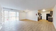 Located at 3600 Ely Pl SE in Washington, DC, this one-bedroom, one-bathroom residence offers a well-organized single-floor layout with a clean, modern aesthetic throughout. The open-concept living and dining area is spacious and bright, featuring light-toned hardwood-style flooring, crisp white walls, and a large sliding glass door with vertical blinds that fills the space with natural light and provides outdoor views. The galley-style kitchen is thoughtfully designed with dark espresso shaker cabinetry, light marble-look countertops, black appliances including a gas range and full-size refrigerator, and an under-cabinet range hood — offering ample storage and prep space in a compact, efficient layout. The bedroom is a comfortable retreat with plush wall-to-wall carpeting, a window with blinds allowing natural light, and a dedicated closet. The bathroom features classic white hexagonal tile flooring, a pedestal sink, a mirror, and a shower/tub combination. Throughout the unit, the neutral color palette and consistent finishes create a cohesive and functional living environment suitable for everyday comfort.