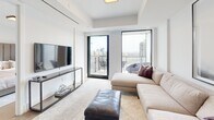 Located in the prestigious Forest Hill neighbourhood of Toronto, this thoughtfully designed one-bedroom, one-bathroom suite on the 12th floor offers an impressive blend of modern sophistication and functional living. The open-concept kitchen and living area serves as the heart of the home, featuring wide-plank hardwood flooring, sleek two-tone cabinetry in warm wood and crisp white, a stone-topped waterfall island with pendant lighting, and a stone backsplash. The living room is bathed in natural light through floor-to-ceiling windows and opens directly onto a private balcony, revealing sweeping views of the Toronto skyline and surrounding treetops. The bedroom is a serene retreat, highlighted by a large window framing city views, light wood flooring, and access to a well-appointed walk-in closet with custom built-in shelving. The bathroom exudes a spa-like quality, finished with large-format marble-look wall tiles, a soaker tub with glass sliding enclosure, and warm stone floor tiles complemented by clean white cabinetry. A welcoming hallway with a dedicated closet completes this elegantly curated suite, offering refined urban living in one of Toronto's most sought-after communities.