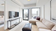 Located in the prestigious Forest Hill neighbourhood of Toronto, this thoughtfully designed one-bedroom, one-bathroom suite on the 12th floor offers an impressive blend of modern sophistication and functional living. The open-concept kitchen and living area serves as the heart of the home, featuring wide-plank hardwood flooring, sleek two-tone cabinetry in warm wood and crisp white, a stone-topped waterfall island with pendant lighting, and a stone backsplash. The living room is bathed in natural light through floor-to-ceiling windows and opens directly onto a private balcony, revealing sweeping views of the Toronto skyline and surrounding treetops. The bedroom is a serene retreat, highlighted by a large window framing city views, light wood flooring, and access to a well-appointed walk-in closet with custom built-in shelving. The bathroom exudes a spa-like quality, finished with large-format marble-look wall tiles, a soaker tub with glass sliding enclosure, and warm stone floor tiles complemented by clean white cabinetry. A welcoming hallway with a dedicated closet completes this elegantly curated suite, offering refined urban living in one of Toronto's most sought-after communities.