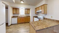 Located at 901 N 35th St in Council Bluffs, Iowa, this two-story home offers a practical and well-organized layout across two floors. The main level features a combined dining and living area with wood-look plank flooring, vertical blinds, and windows that allow natural light to fill the space. The kitchen is equipped with warm oak cabinetry, granite-style countertops, a gas range, dishwasher, and a peninsula that provides additional prep space — all complemented by durable hardwood-style flooring. A hallway connects the main living areas to the staircase leading to the upper level. Upstairs, three bedrooms are finished with plush carpeting and feature windows with outdoor views of the surrounding neighborhood. Each bedroom includes dedicated closet space with oak-finished doors. The home's single full bathroom features a tub-shower combination with chrome fixtures. Throughout the home, textured ceilings, warm wood trim, and neutral wall tones contribute to a clean, move-in ready aesthetic. With four closets distributed across the home, storage is well-accounted for. The layout is efficient and functional, making this a solid two-story home suitable for a variety of living arrangements.