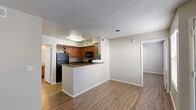 This single-floor residence offers a thoughtfully designed layout that balances functionality and comfort throughout its well-connected spaces. The open-concept living and kitchen area serves as the heart of the unit, where warm wood-look flooring extends seamlessly underfoot. A textured popcorn ceiling and neutral-toned walls create a clean, consistent backdrop throughout.

The kitchen is a standout feature, equipped with rich medium-toned wood cabinetry — including an upper wine rack detail — dark granite countertops, and a peninsula that provides additional prep and bar-style seating space. Black appliances, including a refrigerator, range, microwave, and dishwasher, complement the cabinetry, while a double-basin sink adds practicality. The kitchen transitions naturally into the living area, which benefits from natural light through large windows fitted with horizontal blinds and a ceiling fan overhead.

The bedrooms are generously sized, each featuring the same wood-look flooring and neutral walls, with access to closets — including what appears to be a walk-in configuration. The bathroom includes a wide granite-topped vanity with an undermount sink and a full mirror, conveying a clean and functional design. Throughout, the space maintains a consistent, well-maintained aesthetic suited for everyday living.