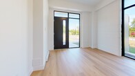 Located at 425 Fourth Street in Gananoque, Ontario, this thoughtfully designed one-bedroom, one-bathroom unit offers a compact yet efficient single-floor layout with contemporary finishes throughout. Light hardwood flooring flows seamlessly across every room, creating a warm and cohesive aesthetic.

The entryway makes an immediate impression with a striking black-framed front door flanked by full-height glass panels, allowing natural light to flood the space and offering a clear view of the outdoors. The galley-style kitchen is well-appointed with light wood cabinetry, matte black hardware, a quartz countertop, subway tile backsplash, and stainless steel appliances. A tall, slender window at the end of the kitchen draws in additional natural light and outdoor views.

The living area is bright and open, complemented by baseboard heating and clean white walls that enhance the airy feel. The bedroom is a comfortable and private retreat, featuring a full-width sliding closet and a large floor-to-ceiling window that frames outdoor greenery, filling the room with natural light. The bathroom is finished in a crisp, all-white palette with a soaker tub and shower combo, light wood vanity, quartz countertop, and a matte black toilet paper holder, lending a clean, modern touch. The unit also features an outdoor deck, visible in the dollhouse view.