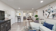 Located at 201 Kingstowne Rd in Newport News, VA, this thoughtfully designed 2-bedroom, 2-bathroom residence offers a comfortable and functional single-floor layout. The open-concept living and dining area is bright and welcoming, featuring wood-style flooring, recessed lighting, and natural light from large windows. The living room provides ample space for relaxing and entertaining, flowing seamlessly into the dining area.

The galley-style kitchen is well-equipped with crisp white shaker cabinets, dark stone-look countertops, black appliances including a refrigerator, range, microwave, and dishwasher, and a pass-through window connecting to the living area. A dedicated laundry space adds everyday convenience.

The primary bedroom is generously sized, featuring plush carpet, multiple closets for abundant storage, and windows overlooking the exterior. The second bedroom is equally comfortable. Both bathrooms are finished with white vanity cabinetry, clean countertops, and wood-style flooring. One bathroom includes a tub/shower combination.

Throughout the residence, a neutral color palette, consistent flooring, and recessed lighting create a cohesive, modern ambiance. Four closets distributed across the home ensure excellent storage capacity for residents.