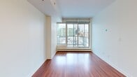 Located on the 6th floor at 1215 5th St SW in Calgary's Beltline neighbourhood, this one-bedroom, one-bathroom unit offers a well-designed layout making efficient use of its compact footprint. Rich hardwood flooring runs throughout, providing warmth and continuity across the living spaces.

The open-concept kitchen and living area serves as the heart of the unit. The kitchen is appointed with sleek white cabinetry, stone countertops, a subway tile backsplash, stainless steel appliances, and a large peninsula island with a double undermount sink — ideal for both meal preparation and casual dining. Pendant lighting above the island adds a polished finishing touch.

Large floor-to-ceiling windows in both the living area and bedroom flood the unit with natural light and frame sweeping views of the Calgary downtown skyline. A balcony is accessible from the living area, extending the usable space outdoors.

The bedroom is a comfortable and well-proportioned retreat, benefiting from the same generous glazing and city views. A dedicated closet provides practical storage. The bathroom features a full soaker tub and shower combination with clean white tile surround, maintaining the unit's crisp, contemporary aesthetic throughout.
