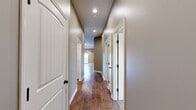 Located at 7901 SW 7th St in Blue Springs, MO, this single-story, 3-bedroom, 2-bathroom home offers a thoughtfully designed layout with quality finishes throughout. The open-concept living room features vaulted ceilings, rich hardwood-style flooring, a ceiling fan, and a sliding glass door that fills the space with natural light and provides direct outdoor access. The kitchen is well-equipped with warm oak cabinetry, granite-look countertops, a tile backsplash, black appliances, and a central island with breakfast bar seating — all complemented by matching hardwood-style flooring. The spacious primary bedroom showcases a tray ceiling with a ceiling fan, plush carpeting, and dual windows that invite natural light. It is accompanied by a dedicated bathroom featuring a walk-in glass-door shower and a vanity with an oil-rubbed bronze faucet. The two additional bedrooms are carpeted and include closet storage and windows overlooking the surroundings. A second full bathroom with a vanity and large mirror serves the remaining bedrooms. A hallway connects all rooms efficiently, rounding out this comfortable and practical single-floor home.